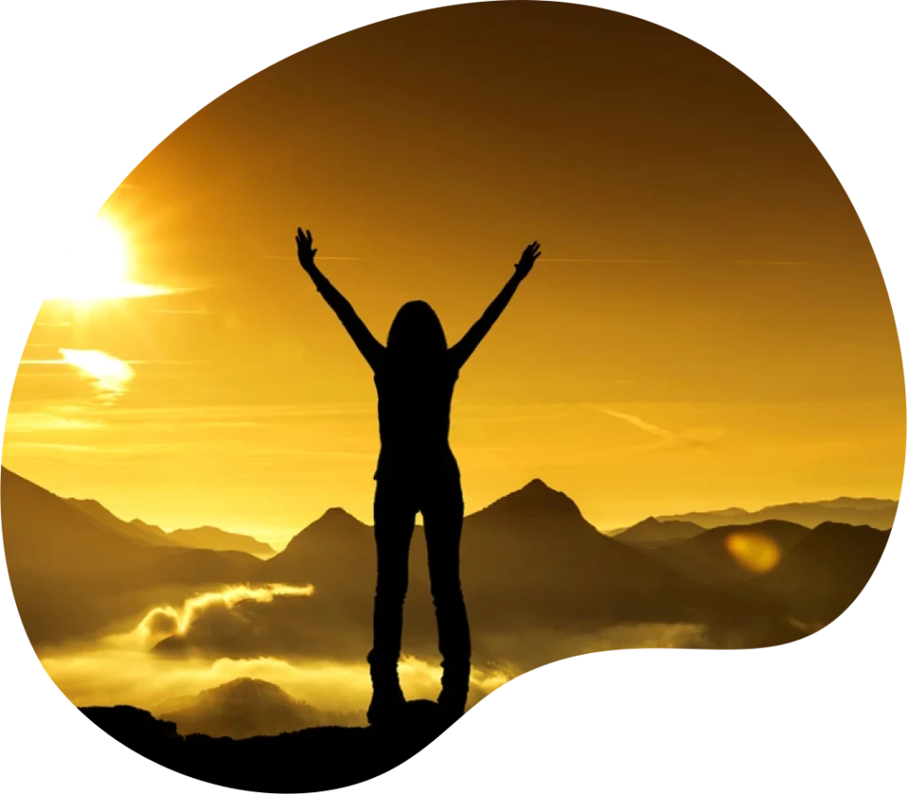 A silhouette of a woman standing with outstretched arms, basking in the golden light of the sunrise over the mountains, symbolizing empowerment, strength, and new beginnings.